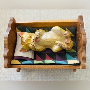 Cute, sleepy kitty in wooden crib